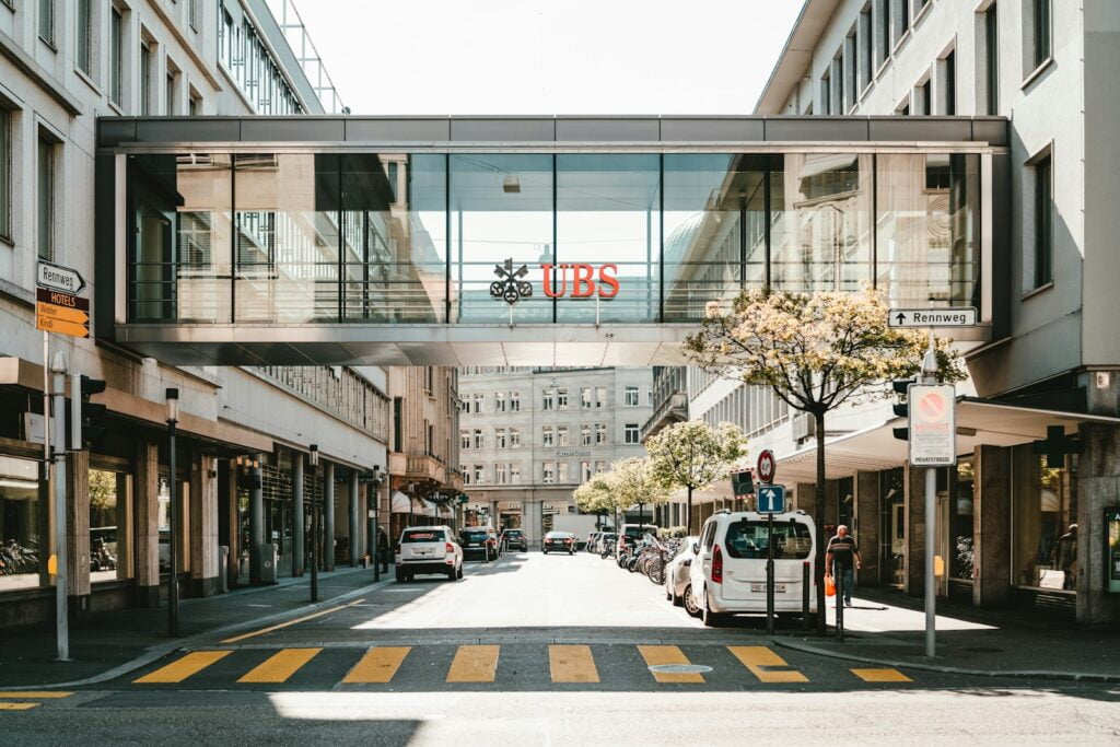UBS logo on glass bridge wall during daytime as symbol of a swiss bank account